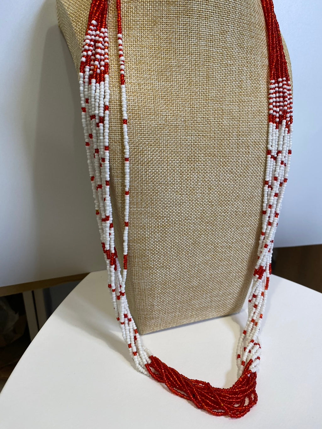 赤と白の長いネックレス。