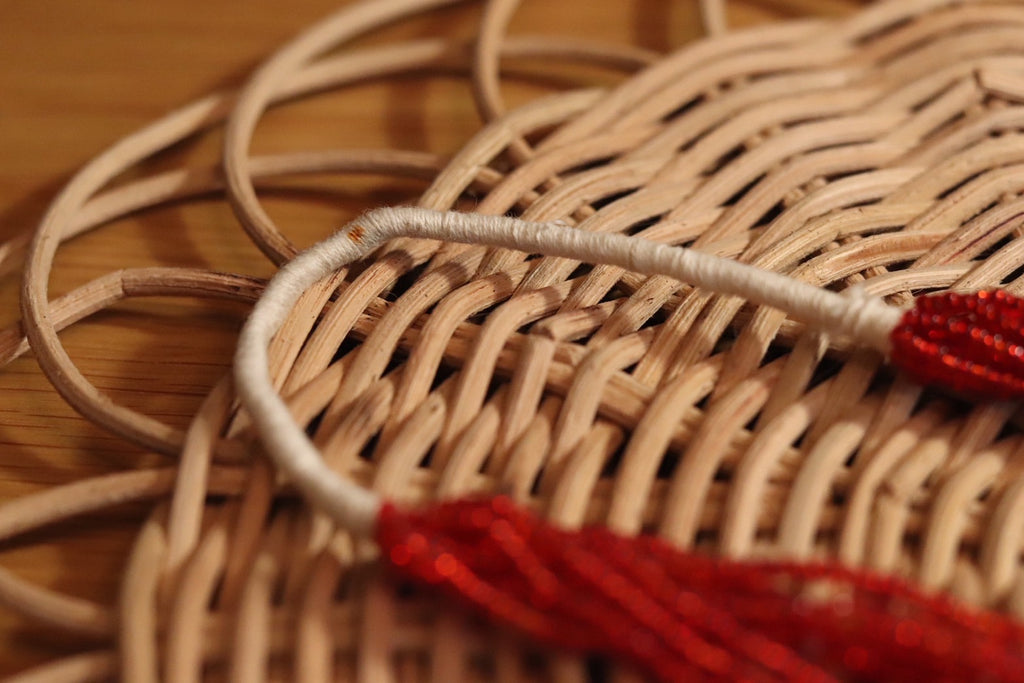 赤と白の長いネックレス。